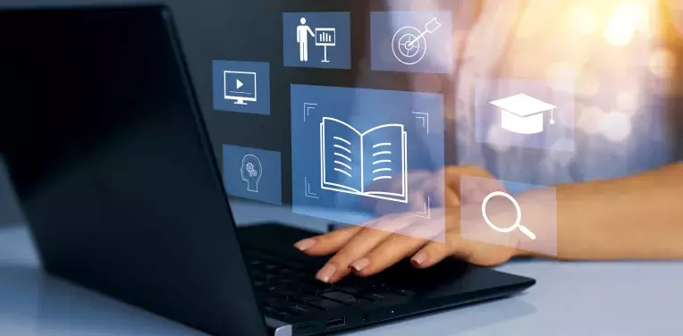 hands typing on a laptop, icons with books, people etc. are floating in front of the screen