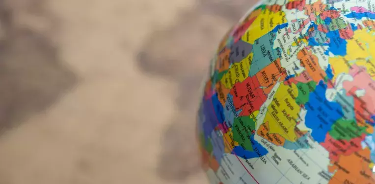 Globe in front of a world map